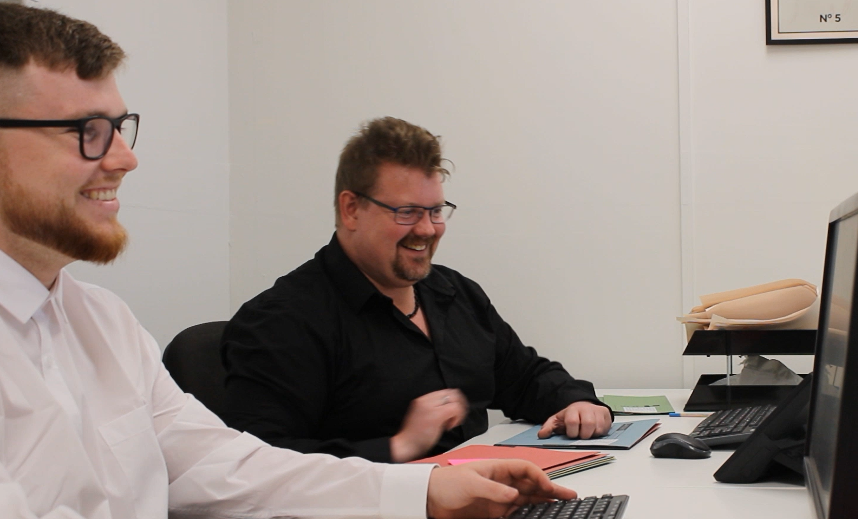 Learner and employer smiling in an office