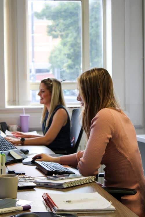 Recruitment executives sat at shared desk working